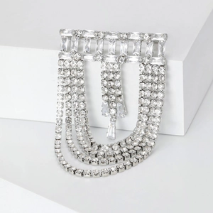 Close-up of silver multilayer fringe brooch with crystal tassels and geometric design