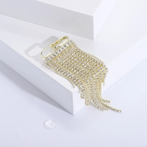 Elegant gold brooch featuring long rhinestone tassels on minimalist white background