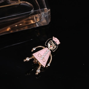 Détail de la broche infirmière en émail rose avec perles et cristaux sur fond noir poli