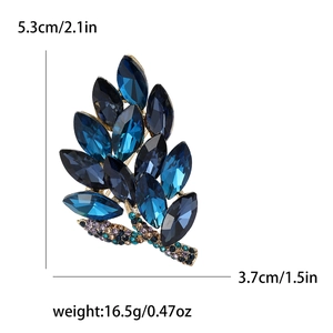 Macro detail of blue crystal leaf brooch showing dimensions 5.3cm x 3.7cm and craft