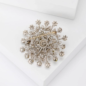 Back view of silver snowflake brooch with gold pin and hollowed-out rhinestone setting