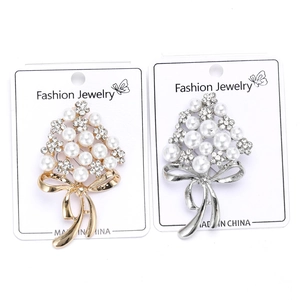 Detail view of gold and silver bouquet brooches with pearls and crystals on card