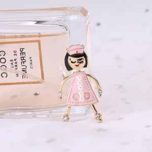Détail d'une broche infirmière en émail rose avec perles blanches et cristaux brillants