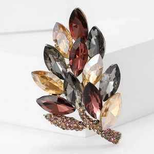 Macro view of crystal leaf brooch with multicolored rhinestones on a white stand
