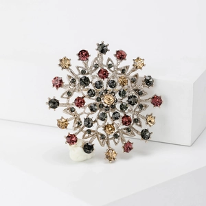 Vintage floral crystal brooch with multicolored rhinestones on white geometric stand