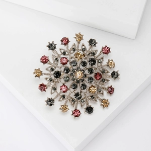 Vintage snowflake flower brooch with multicolored rhinestones on a silver base