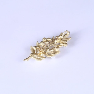 Macro shot showing the gold leaf brooch back with safety pin and pendant hook detail