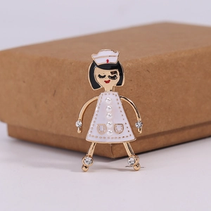 Détail de la broche infirmière avec robe en émail blanc et décorations en perles