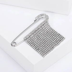 Spilla a frange d'argento con strass scintillanti su supporto geometrico bianco