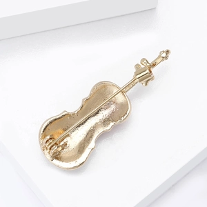Détail du fermoir à épingle sécurisé au dos de la broche violon dorée élégante