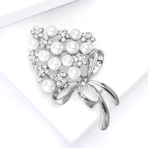 Detailed macro view of rhinestone flower brooch with pearls and silver ribbon bow