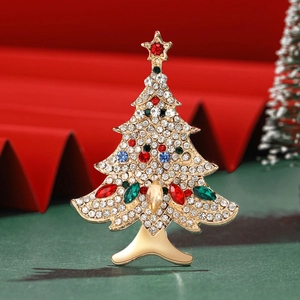 Detailed view of elegant Christmas tree brooch with colorful rhinestones on golden alloy