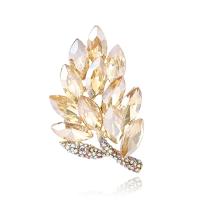 Elegant gold leaf brooch with champagne crystals and aurora rhinestones on white background