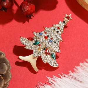 Elegant gold-tone Christmas tree brooch with colorful rhinestones on a festive background