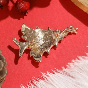 Detailed back view of a gold Christmas tree brooch with a secure safety pin closure