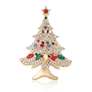 Elegant Christmas tree brooch with gold metal and colorful rhinestones on white background