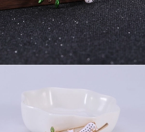 Détail d'une broche chat blanc créative avec pois noirs sur une branche dorée