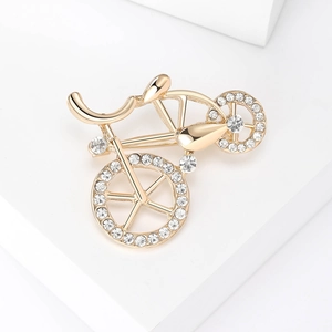 Macro shot of gold plated bicycle brooch with sparkling white crystal inlay details