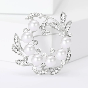 Elegant silver pearl wreath brooch with sparkling zircons on white minimalist display