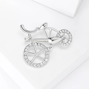 Detail view of bicycle brooch with rhinestones on a white geometric display stand