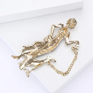Detailed macro view of the gold enamel lady brooch with textured molten lava metal finish