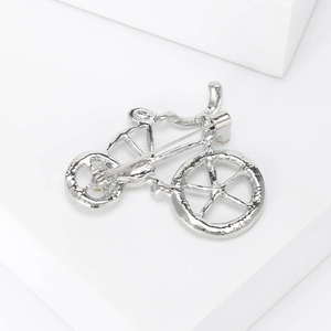 Detail of creative bicycle brooch in silver alloy with rhinestones and safety pin back