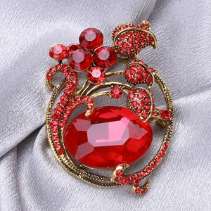 Detailed view of vintage tulip brooch with red crystal and antique gold finish
