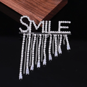Détail de la broche SMILE argentée avec glands en strass scintillants et cristaux de zircon