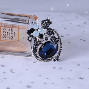 Macro shot of vintage brooch with deep blue faceted gemstone and cat-eye stones