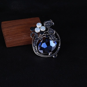 Macro shot of vintage tulip brooch with deep blue gemstones and antique silver floral base