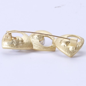 Minimalist gold freshwater pearl brooch featuring a secure pin clasp and brushed metal texture