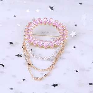 Broche en cristal marquise rose avec glands dorés et perles sur fond de tulle blanc