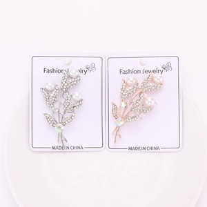 Vue détaillée de broches florales argentées et dorées avec strass et perles blanches