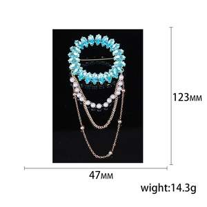 Broche de luxe élégante avec cristaux bleu clair et perles blanches sur fond noir