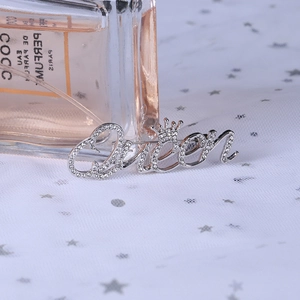 Detail of silver 'Queen' brooch with crown design and sparkling crystal inlay