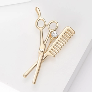 Detail shot of golden scissor and comb barber brooch with a sparkling crystal accent