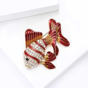 Vue macro de la broche poisson rouge en émail rouge et strass blancs scintillants