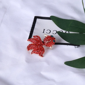Gros plan détaillé d'une broche carpe koi rouge étincelante avec cristaux et finition dorée