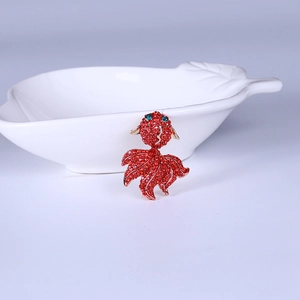 Vue détaillée d'une broche carpe koi rouge avec strass et finition en métal doré
