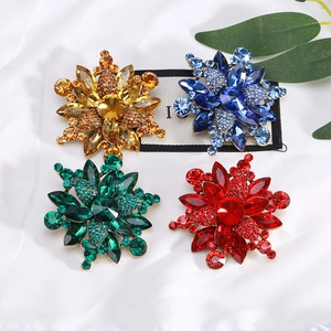 Detailed view of alloy flower brooches with colorful crystals in amber, blue, green and red