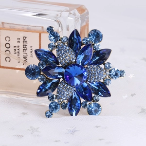 Macro shot of large blue crystal flower brooch with vintage gold setting on tulle