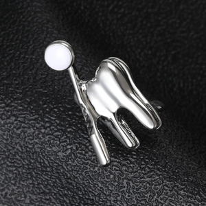 Détail de la broche chameau argentée avec émail blanc sur fond de cuir noir