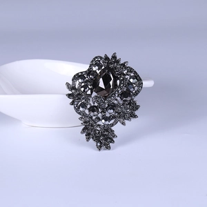 Detailed close-up of a vintage baroque rhinestone brooch with dark smoky gray crystals
