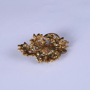 Vintage gold hollow-out rhinestone brooch showing the back view and safety pin clasp