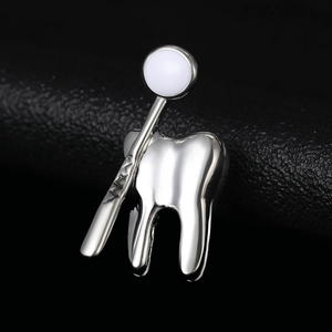 Détail d'une broche dentaire en argent poli avec miroir sur fond de texture noire