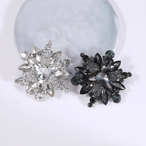 Exquisite snowflake brooches with crystal rhinestones on a marble display plate