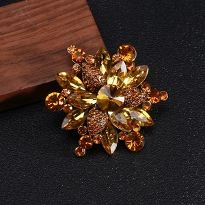 Macro shot of amber crystal flower brooch on black leather surface with wood accent