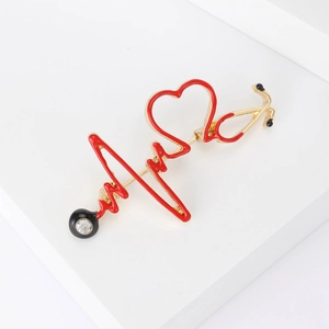 Détail de la broche stéthoscope cœur avec émail rouge et strass brillants