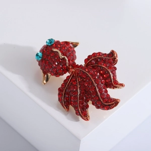 Broche carpe koï raffinée avec strass rouges et bleus sur base plaquée or