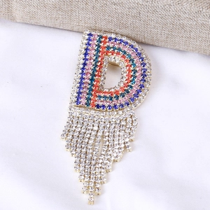 Dettaglio della spilla lettera D con strass colorati e nappe di cristallo pendenti